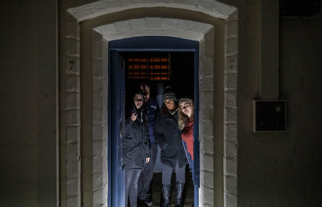 Visitors looking into a prison cell during Ghost Hunting Behind Bars