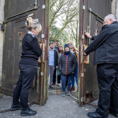 Two officers welcoming visitors through the main prison gate