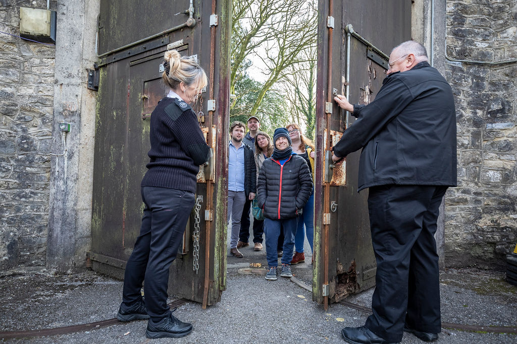 Two officers welcoming visitors through the main prison gate