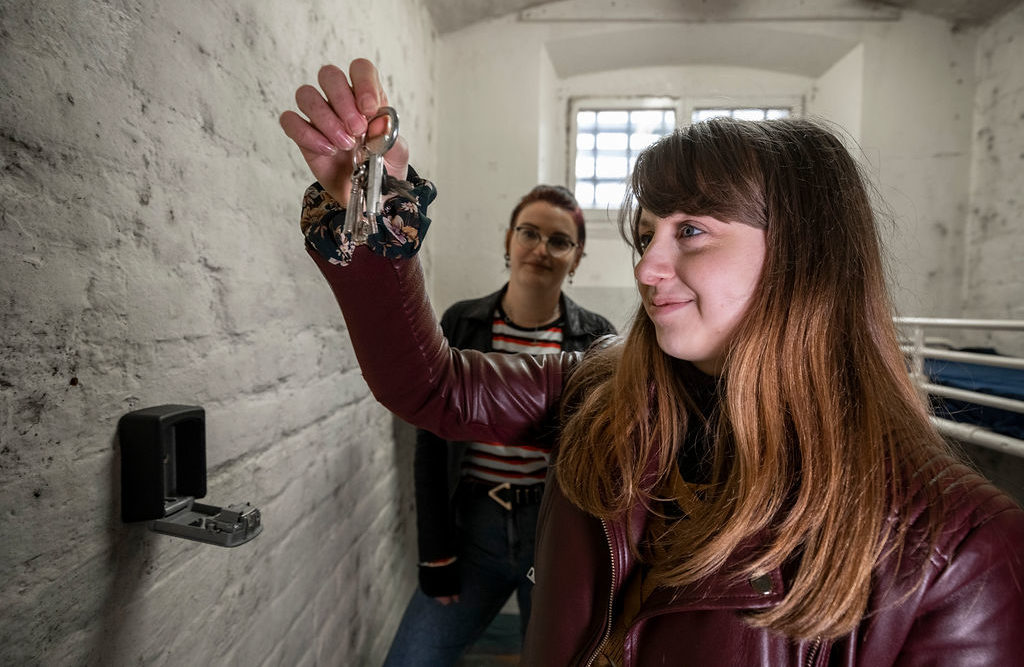 A visitor holding a key during The Cell Escape Room